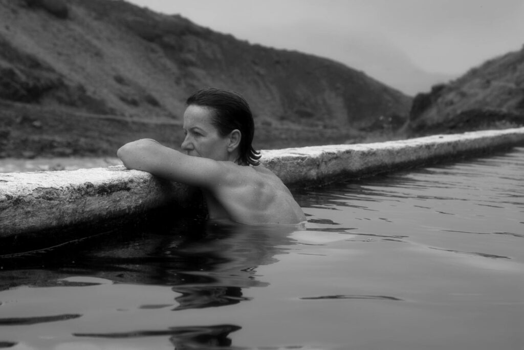 A serene moment captured in a hot spring pool in Iceland, set in grayscale.